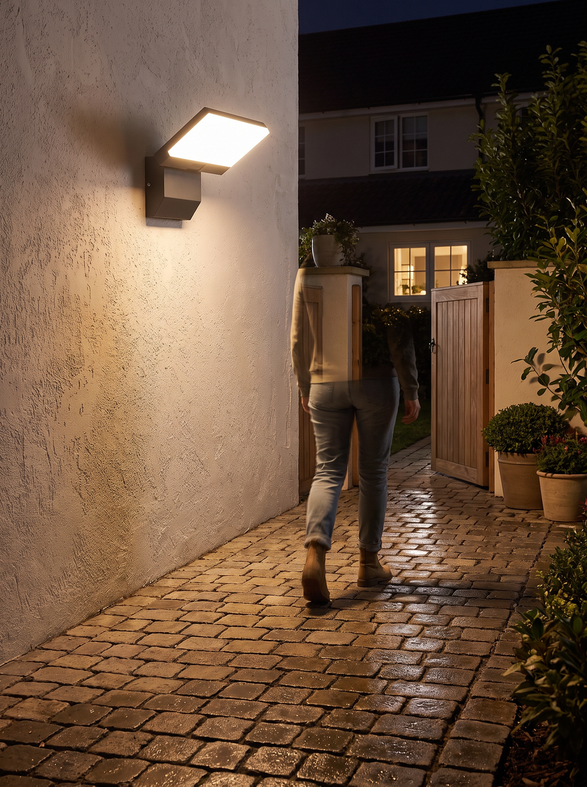 LumiFold Outdoor Wall Light lighting a path as someone approaches